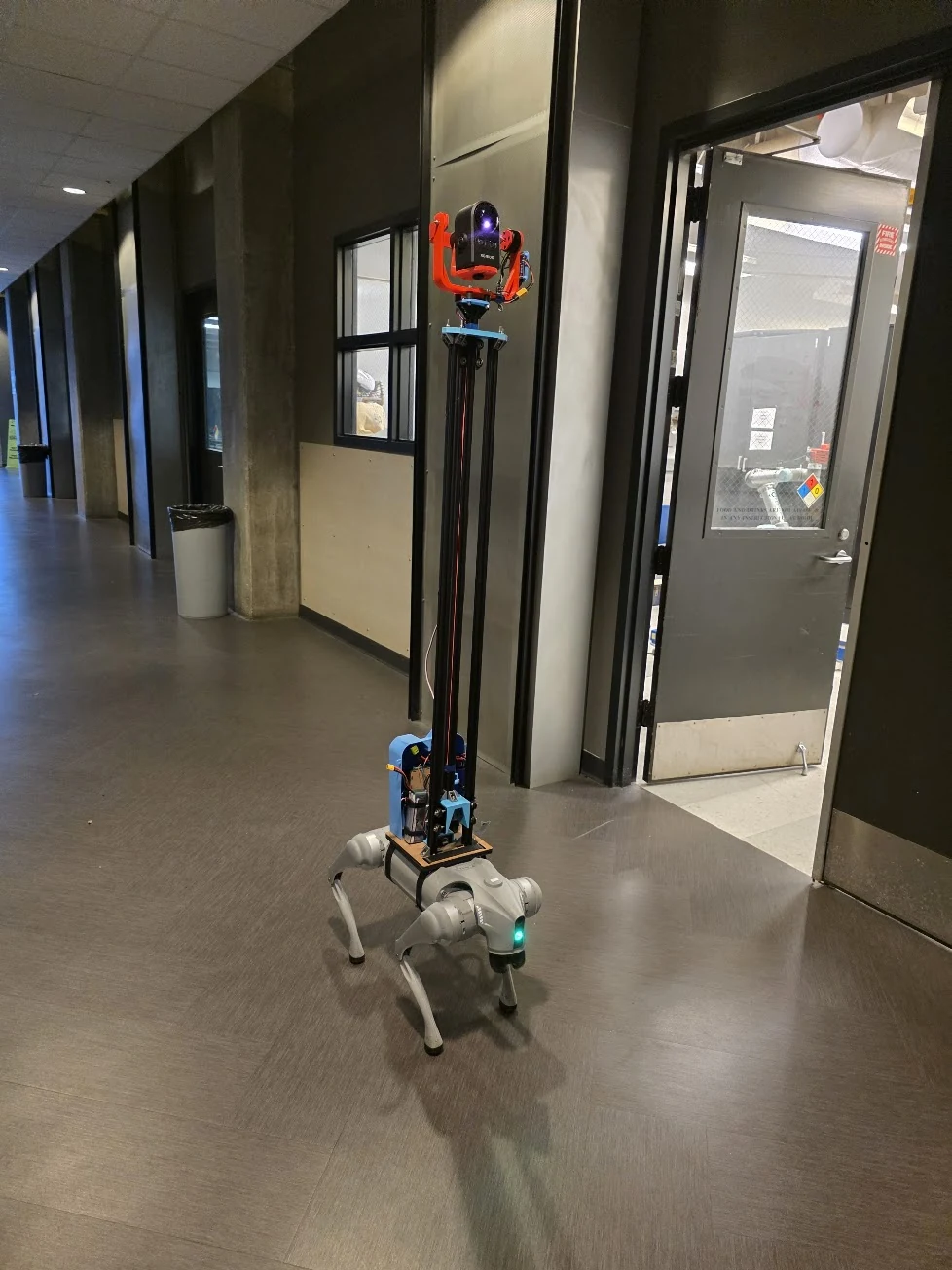 Completed height-adjustable camera rig mounted on a Unitree quadruped robot in a hallway